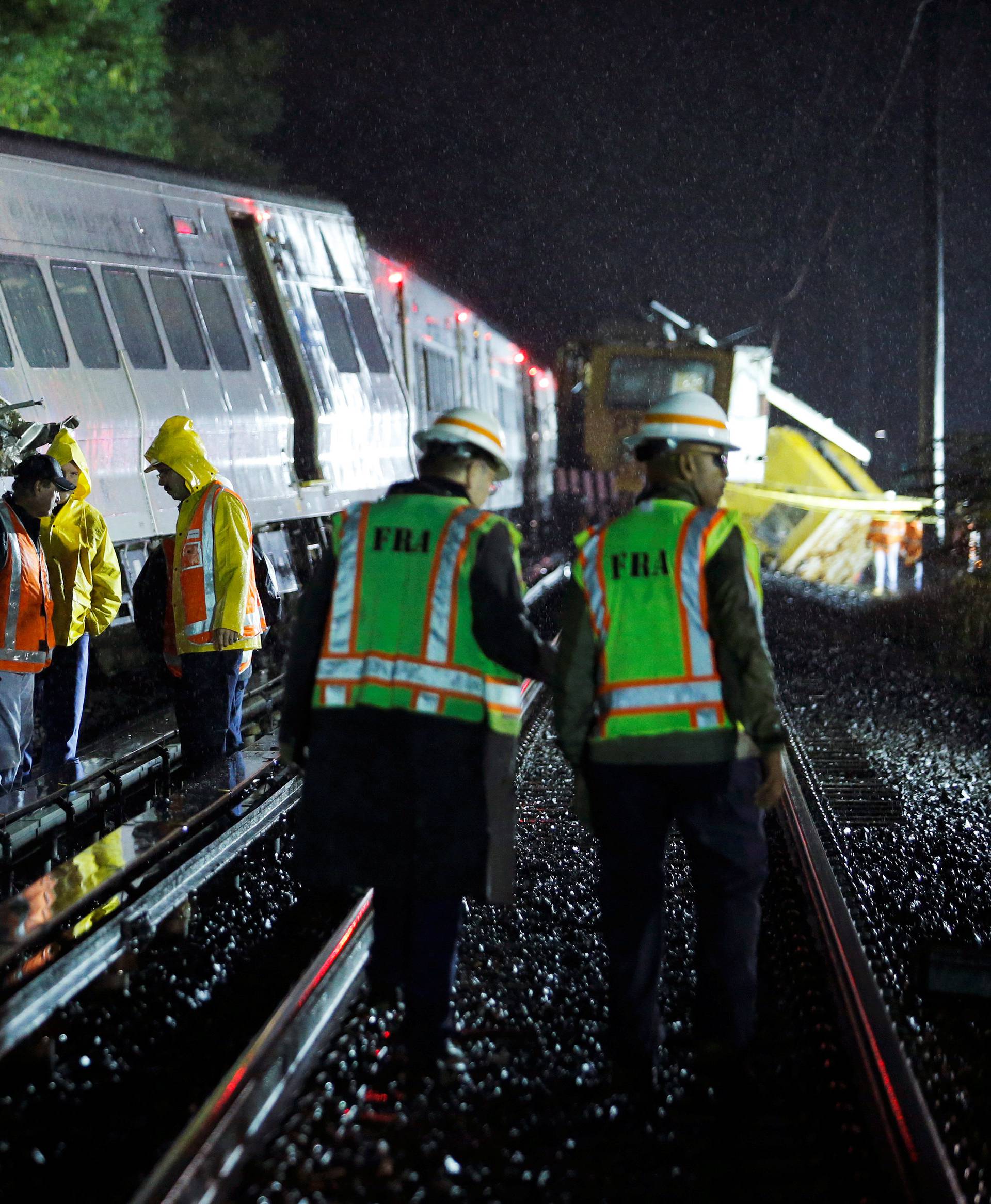 Emergency responders work near a train that sits derailed near the community of New Hyde Park on Long Island in New York