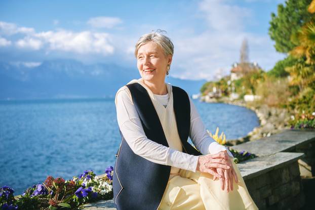 Outdoor portrait of beautiful 55 - 60 year old woman enjoying nice sunny day by the lakeside, image taken in Montreux, Switzerland
