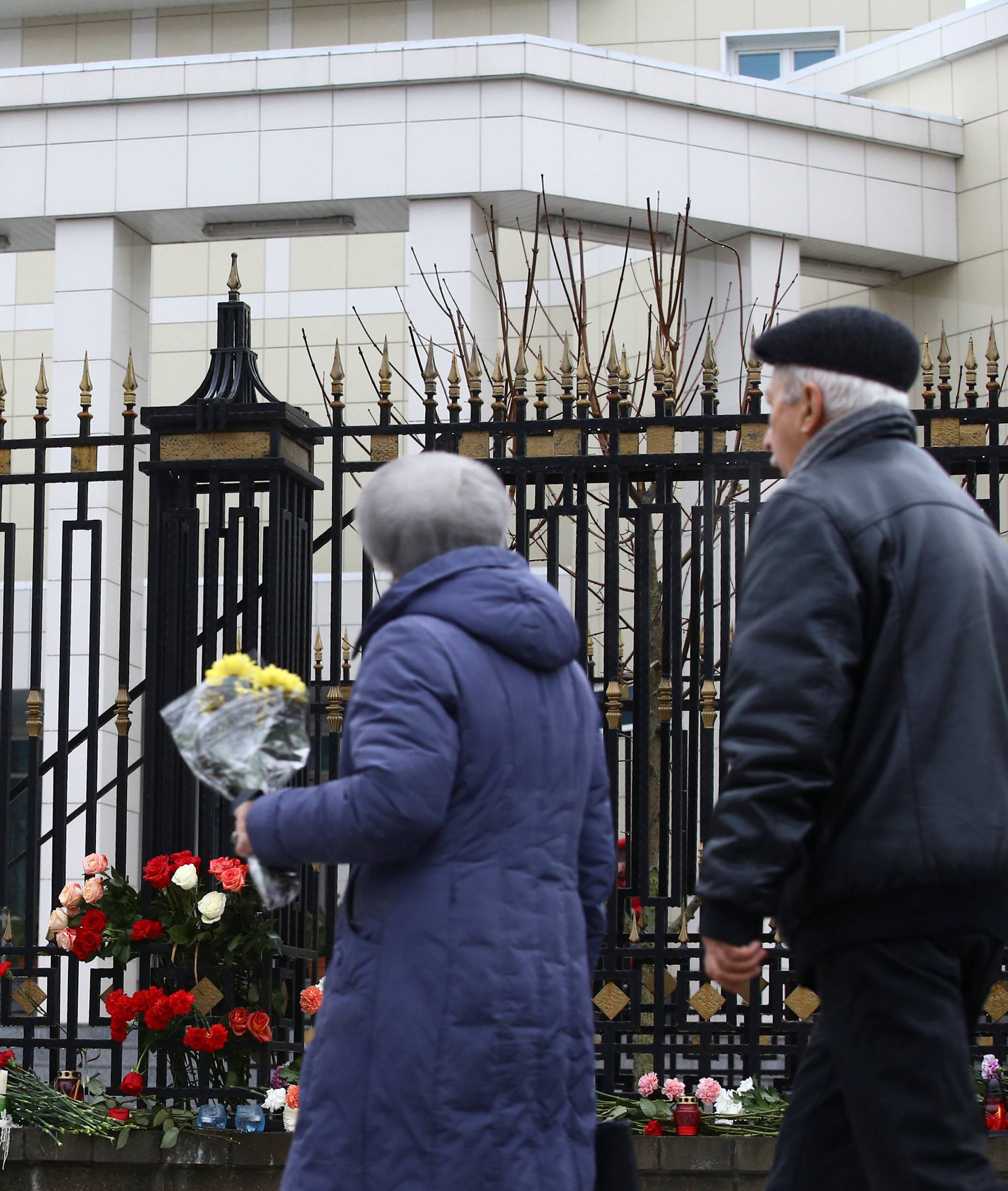 People place flowers to commemorate passengers and crew members of Russian military plane, which crashed into the Black Sea on its way to Syria on Sunday, at the Russian embassy in Minsk