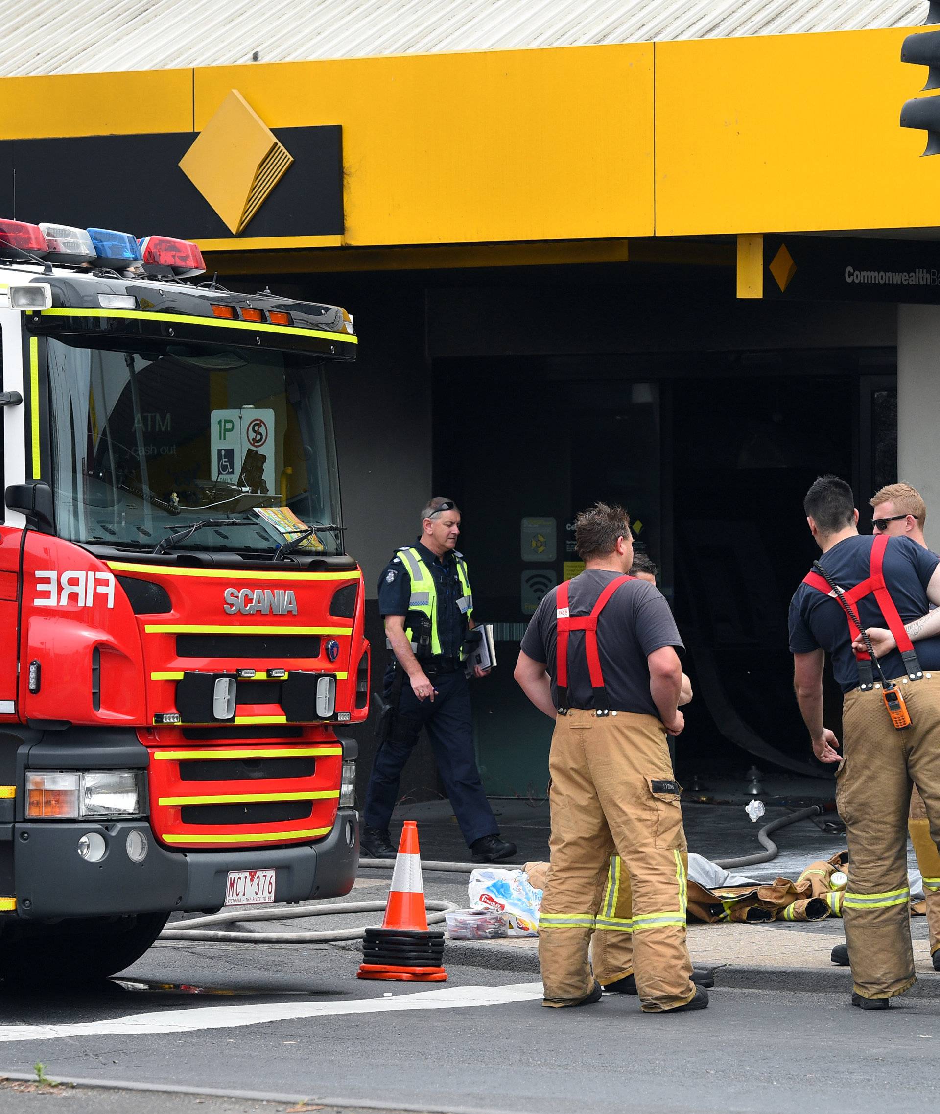 Emergency service workers are seen at a branch of the Commonwealth Bank after a fire injured customers in Melbourne