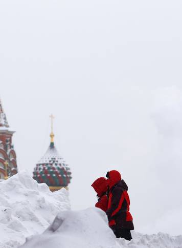 People walk in Red Square near the St Basil's Cathedral after a heavy snowfall in central Moscow