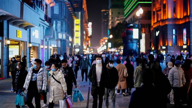 People wearing face masks are seen at a main shopping area almost a year after the global outbreak of the coronavirus disease (COVID-19) in Wuhan