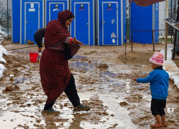 Displaced Palestinians shelter in a tent camp, on a rainy day in Nuseirat