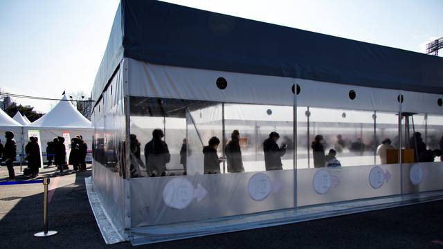 People wait in line to undergo the COVID-19 test at a temporary testing site set up in Seoul