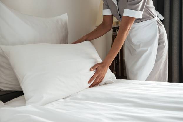 Cropped,Image,Of,A,Female,Chambermaid,Making,Bed,In,Hotel