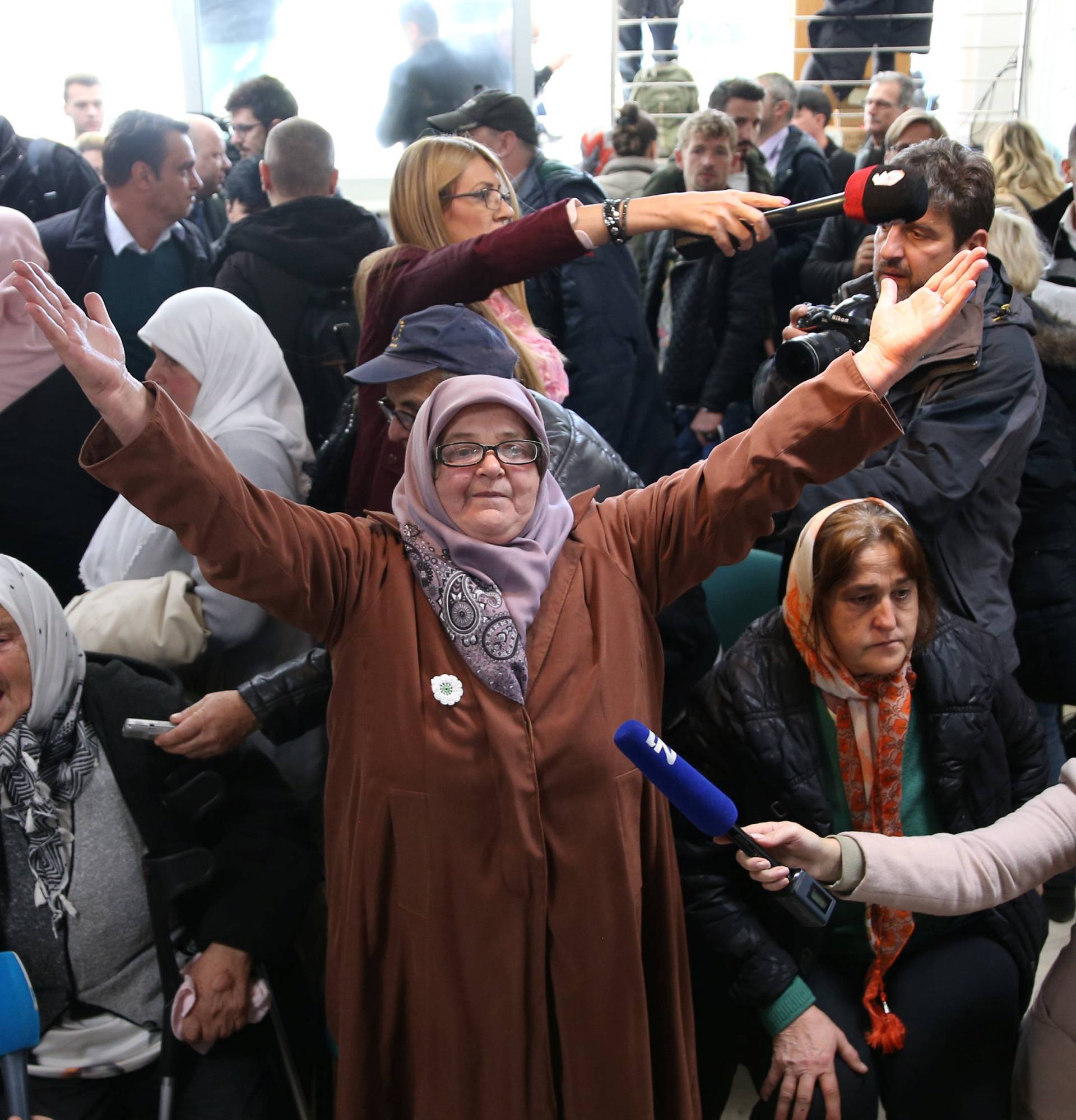 A woman reacts as she watches a television broadcast of the court proceedings of former Bosnian Serb general Ratko Mladic in the Memorial centre Potocari near Srebrenica