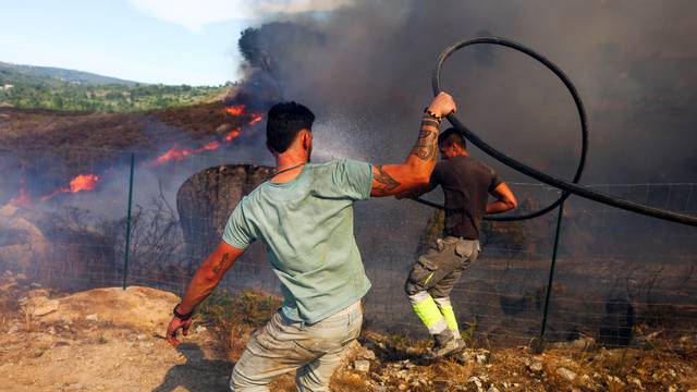 Locals try to extinguish a wildfire in Penalva do Castelo