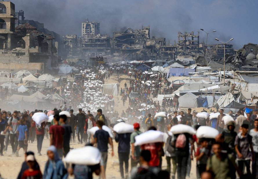 FILE PHOTO: Palestinians gather to receive aid supplies amid a hunger crisis, in Beit Lahia