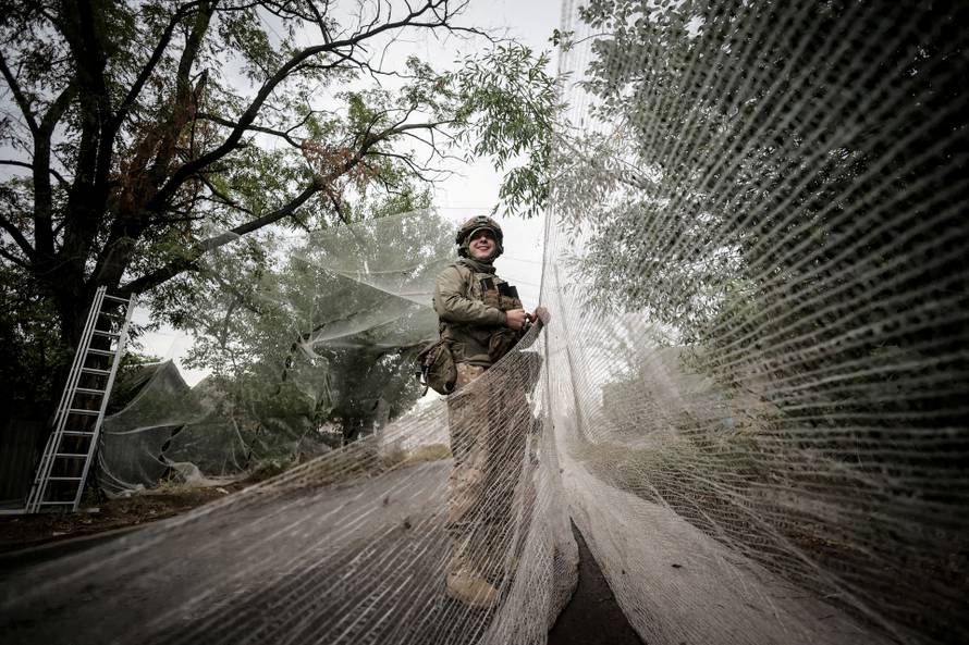 FILE PHOTO: Ukrainian serviceman installs anti-drone nets over a road in the frontline town of Kostiantynivka