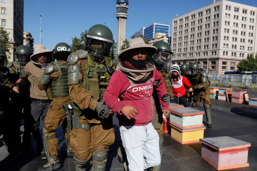 Beekeepers take part in a protest with honeycombs full of bees in front of the Chilean presidential palace in Santiago