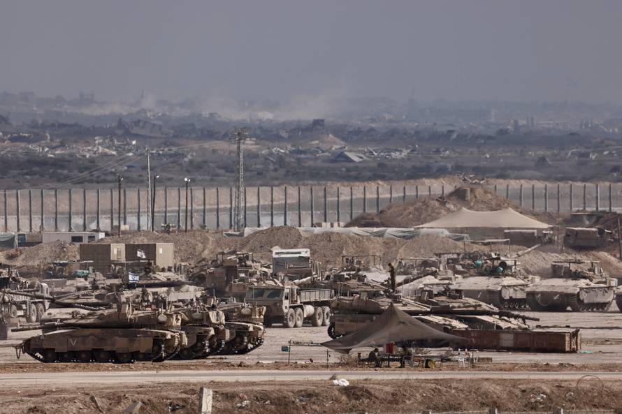 Israeli soldiers gather on the Israeli side of the border with Gaza