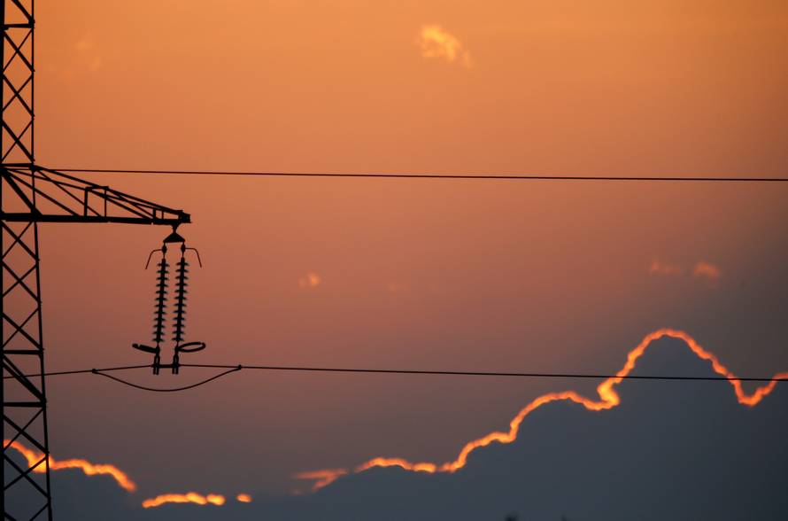 Electrical power pylons of high-tension electricity power lines are seen at sunset in Cambligneul
