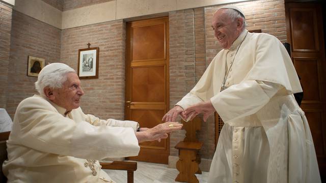 FILE PHOTO: Pope Francis and Pope Emeritus Benedict XVI meet with new cardinals at the Vatican