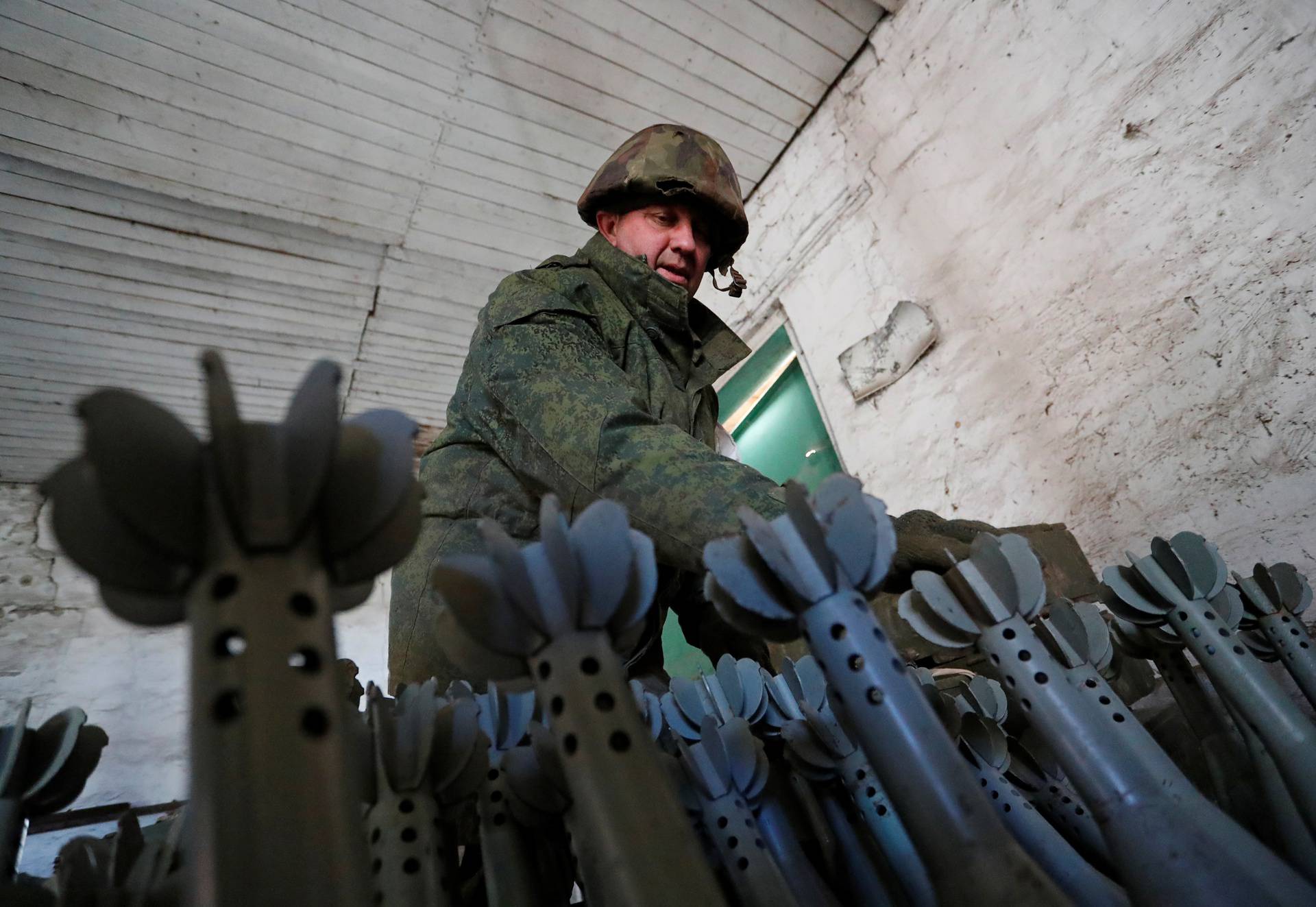 A service member of pro-Russian troops in uniform without insignia is seen at the weapons depot near Marinka