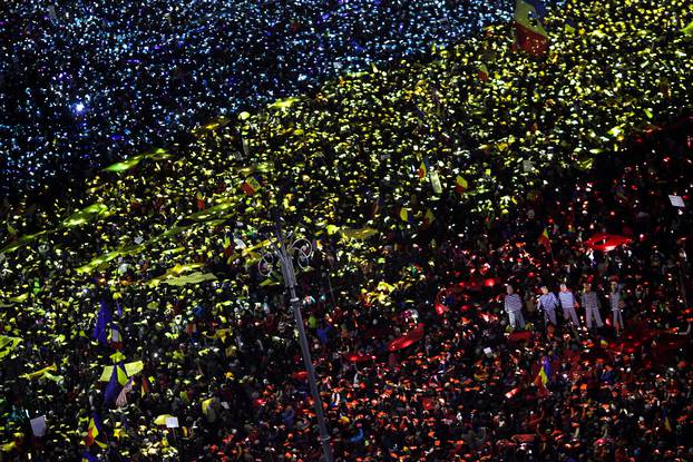 Protesters display the Romanian national flag colours during a demonstration in front of the government building in Bucharest