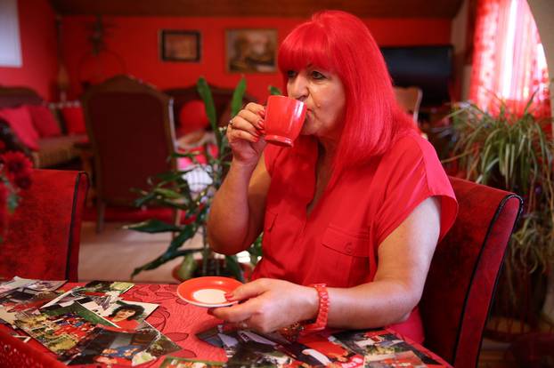 Zorica Rebernik, obsessed with the red color, drinks coffee in her house in the village of Breze near Tuzla
