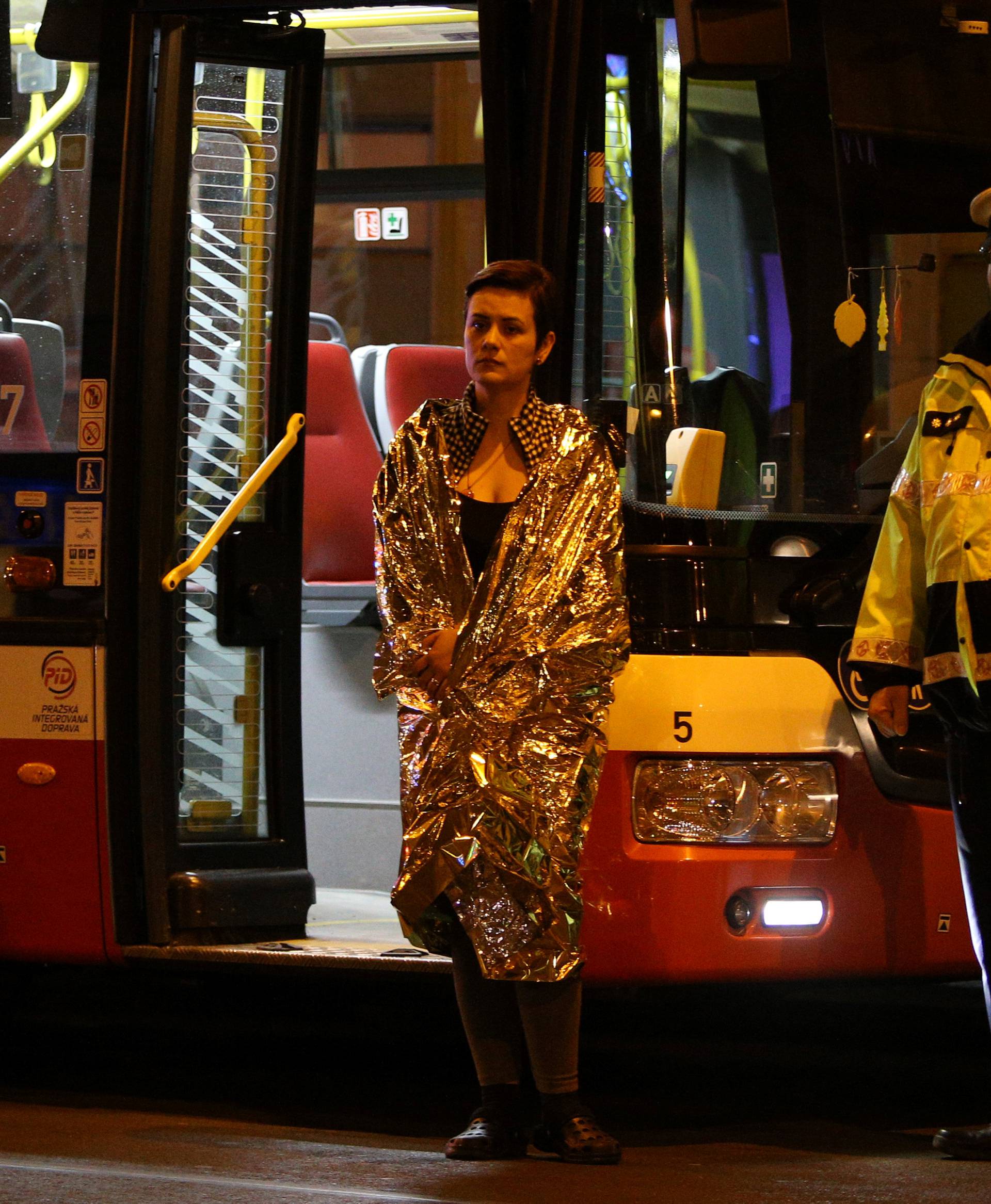 A woman is evacuated from the scene of a fire at a hotel in Prague