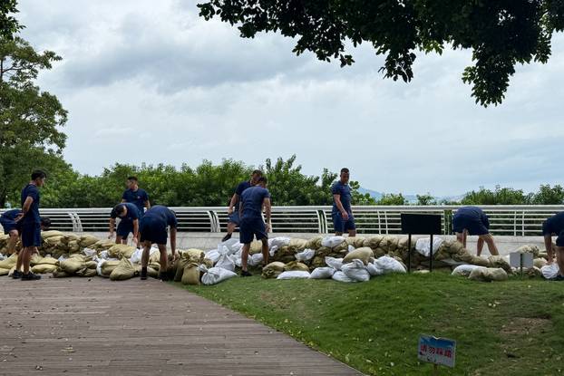 Emergency team members place sandbags at the Shekou waterfront as Super Typhoon Ragasa approaches, in Shenzhen
