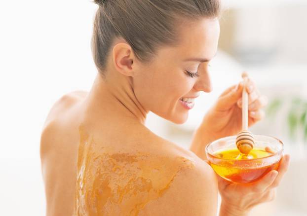Happy young woman enjoying honey spa therapy