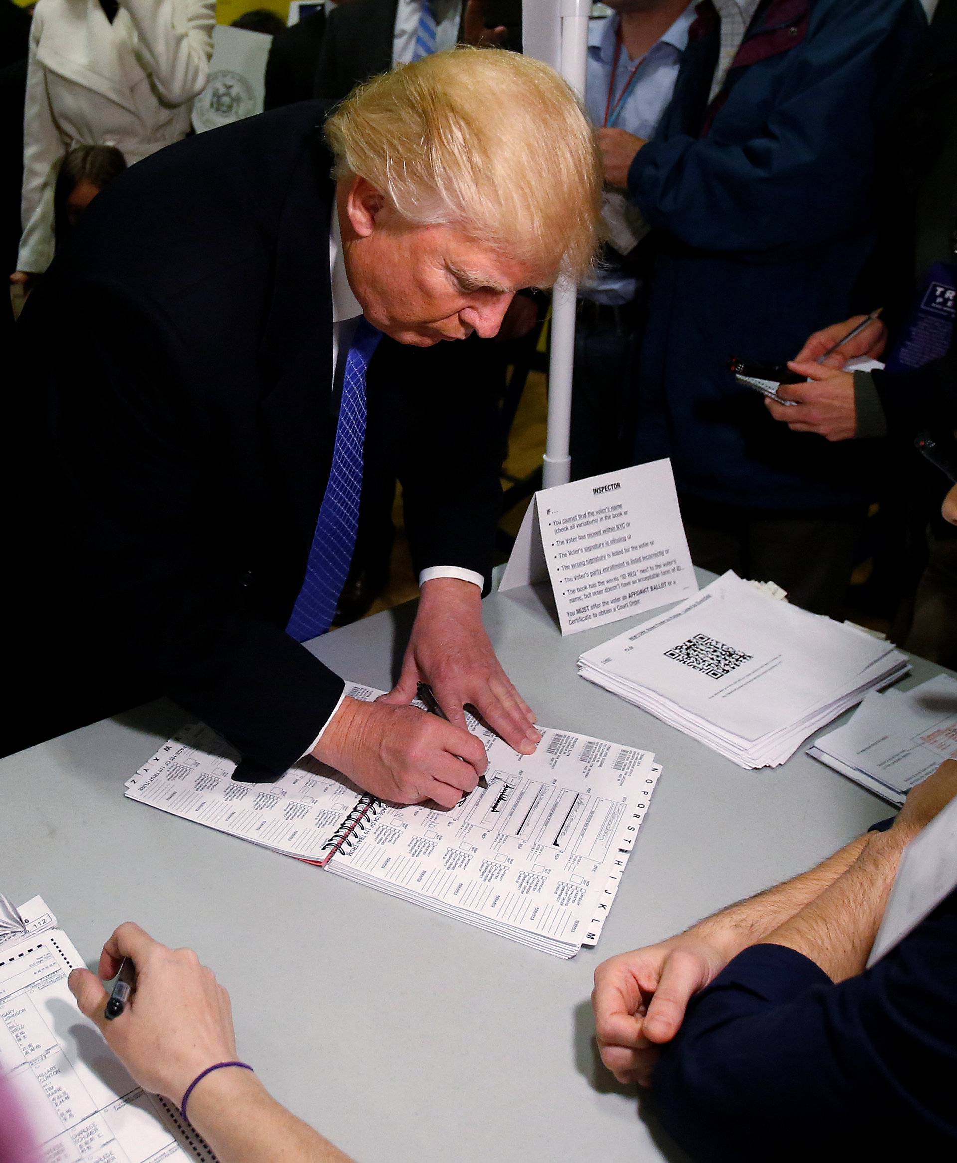 Republican presidential nominee Donald Trump signs his name before he votes at PS 59 in New York