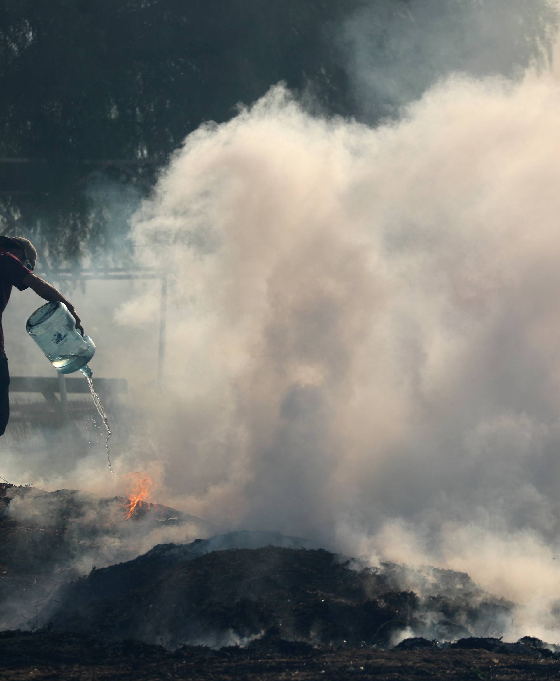 Ranch hands do what they can to try and put out flames after the Lilac Fire, a fast moving wild fire, came through Bonsall, California