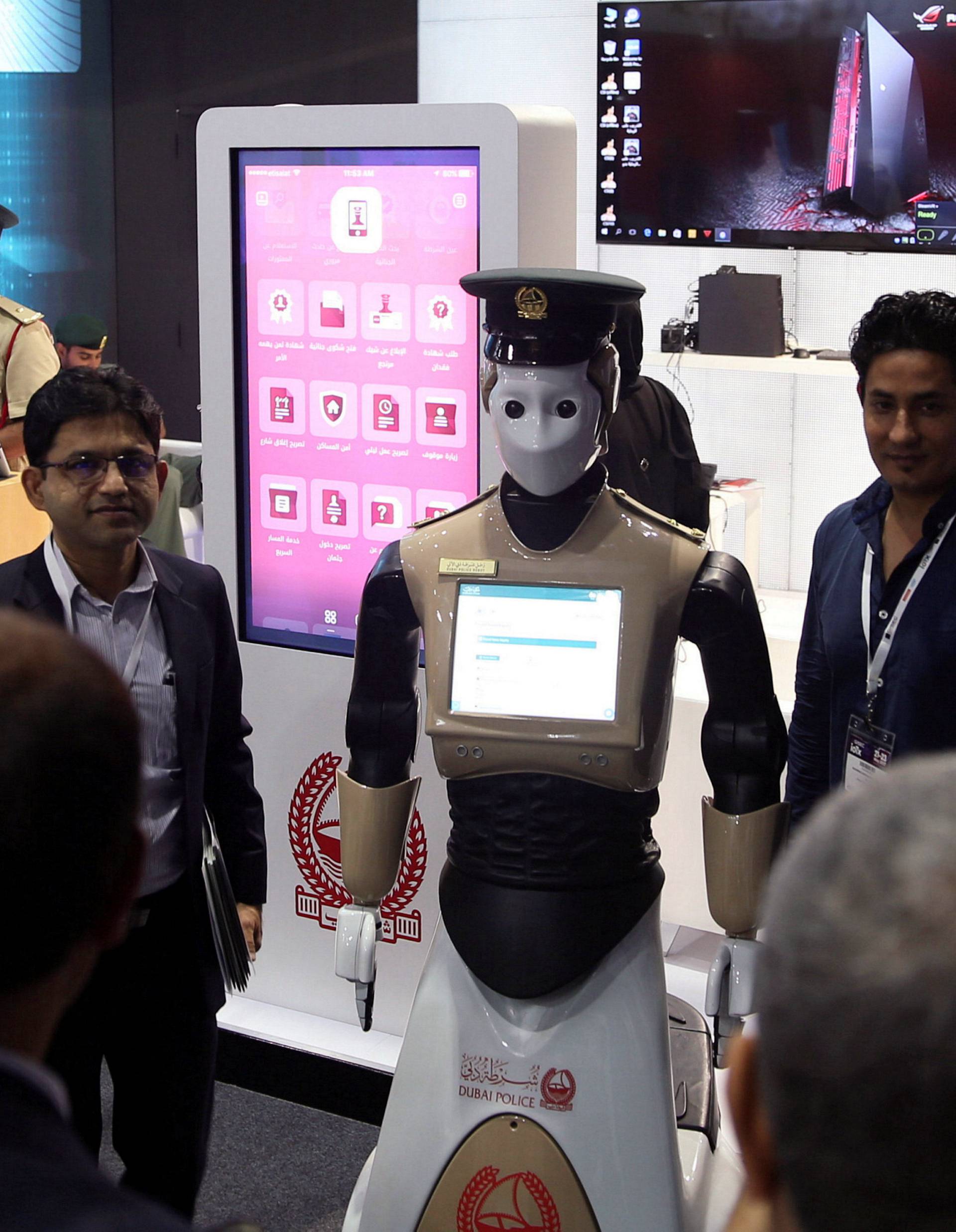 Visitors stand around an operational robot policeman at the opening of the 4th Gulf Information Security Expo and Conference (GISEC) in Dubai