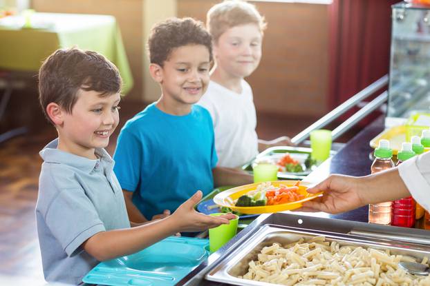 Cropped,Image,Of,Woman,Serving,Food,To,Schoolchildren,In,Canteen