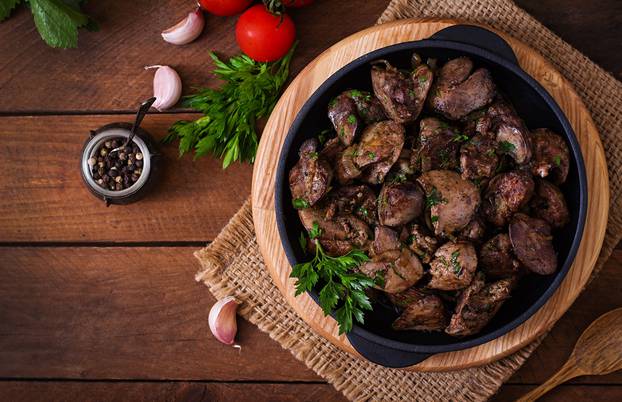 Fried chicken liver with onions and herbs. Top view