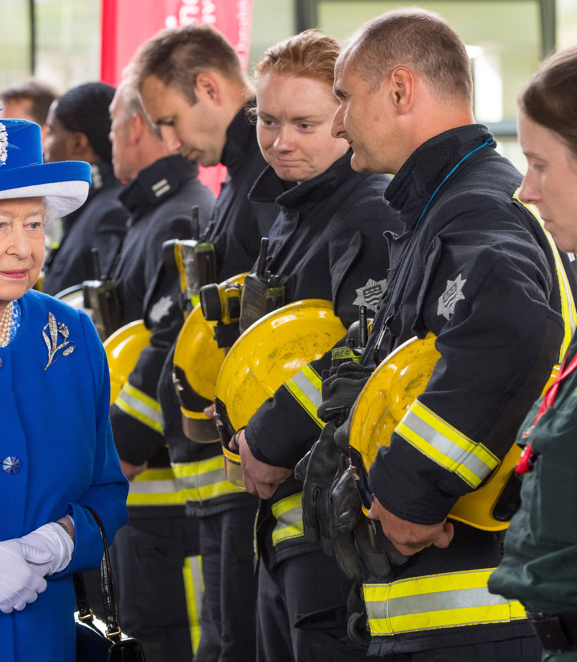 Britain's Queen Elizabeth meets firefighters during a visit to the Westway Sports Centre following the fire at the Grenfell Tower block, in north Kensington, West London