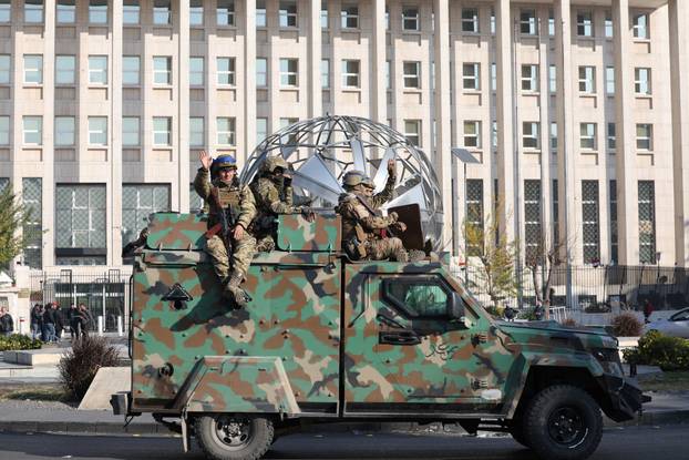Rebel fighters ride on a vehicle, in Damascus