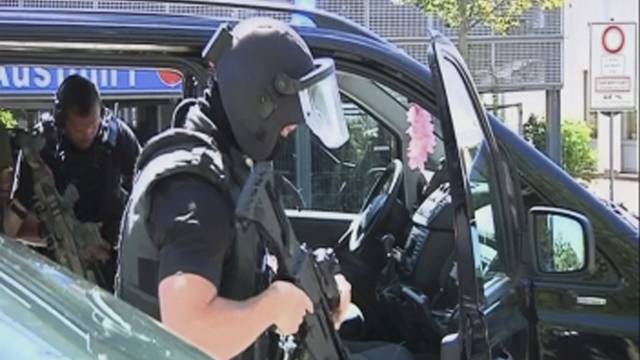 German special police leave their cars after a masked man with a gun and ammunition belt opened fire in a cinema complex in Viernheim