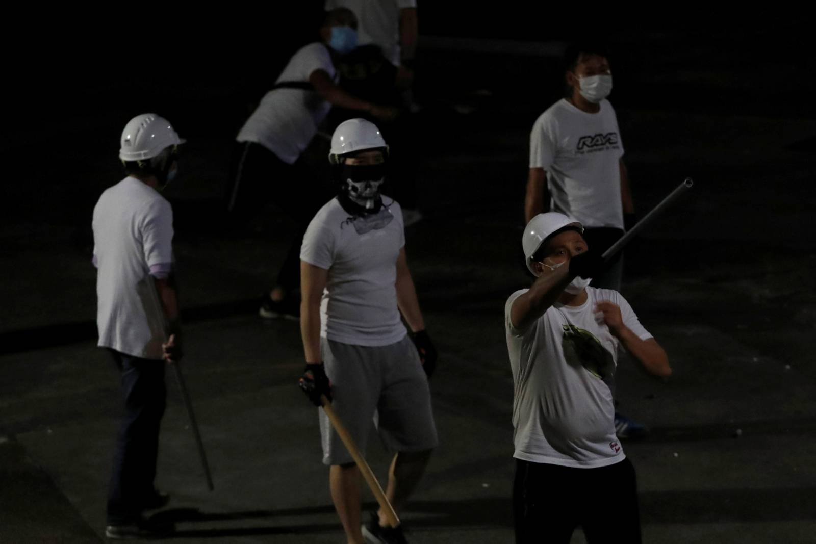 Men in white T-shirts react in Yuen Long after attacking anti-extradition bill demonstrators at a train station in Hong Kong
