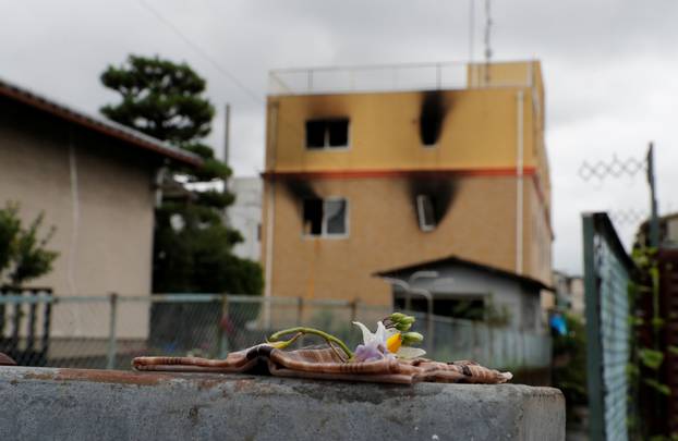 Flowers are placed in front of the torched Kyoto Animation building to mourn the victims of the arson attack, in Kyoto