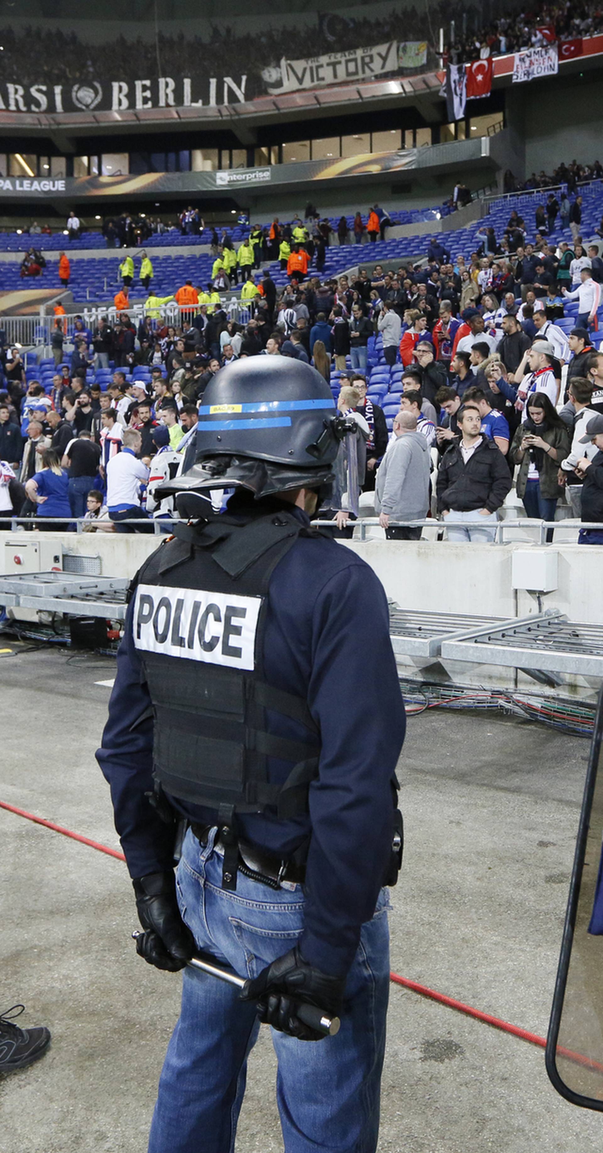 Police officers by the pitch after Lyon and Besiktas fans clashed in the stands