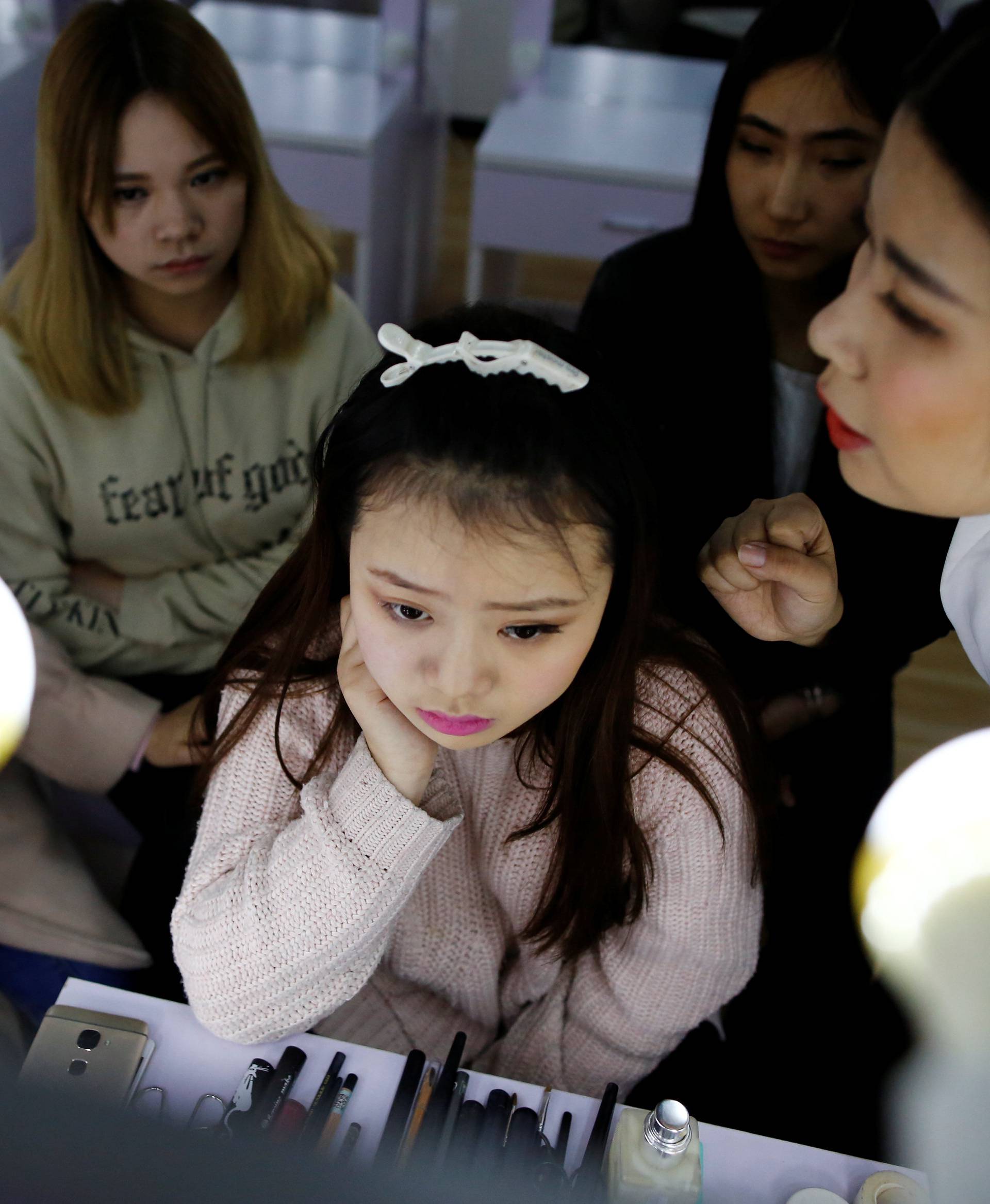Girls attend make-up training session at live streaming talent agency Three Minute TV, in Beijing