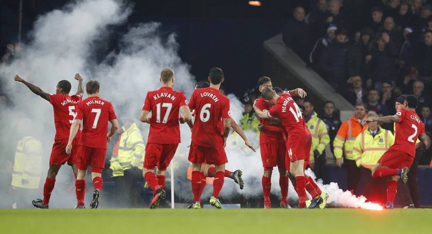 Liverpool's Sadio Mane celebrates scoring their first goal with teammates as a flair lands on the pitch