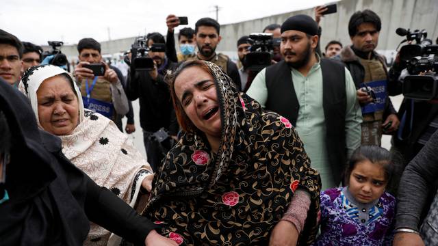 An Afghan Sikh woman mourns for her relatives near the site of an attack in Kabul