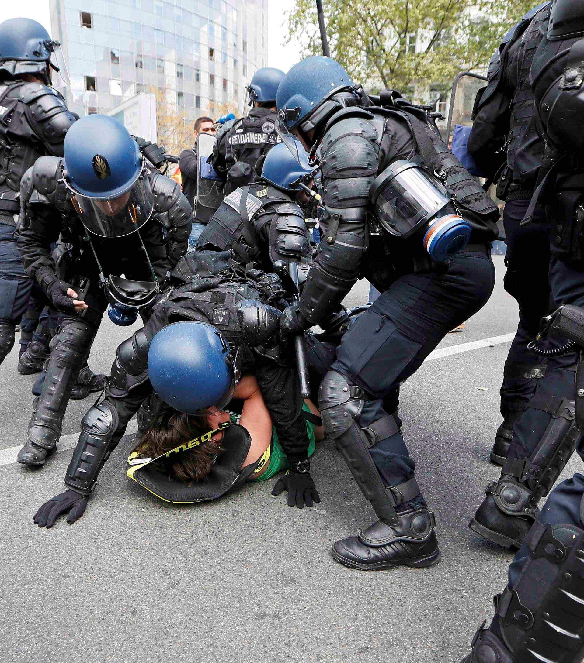 French riot police officers detain a protestor during a demonstration against the French labour law proposal in Lyon
