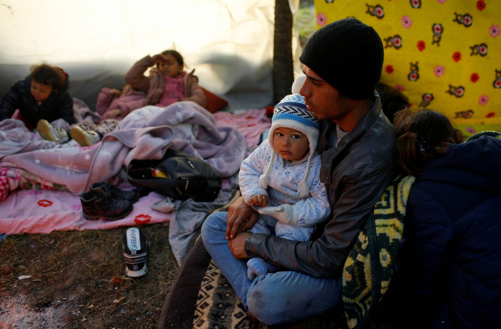 Migrants rest near Turkey's Pazarkule border crossing with Greece's Kastanies, near Edirne