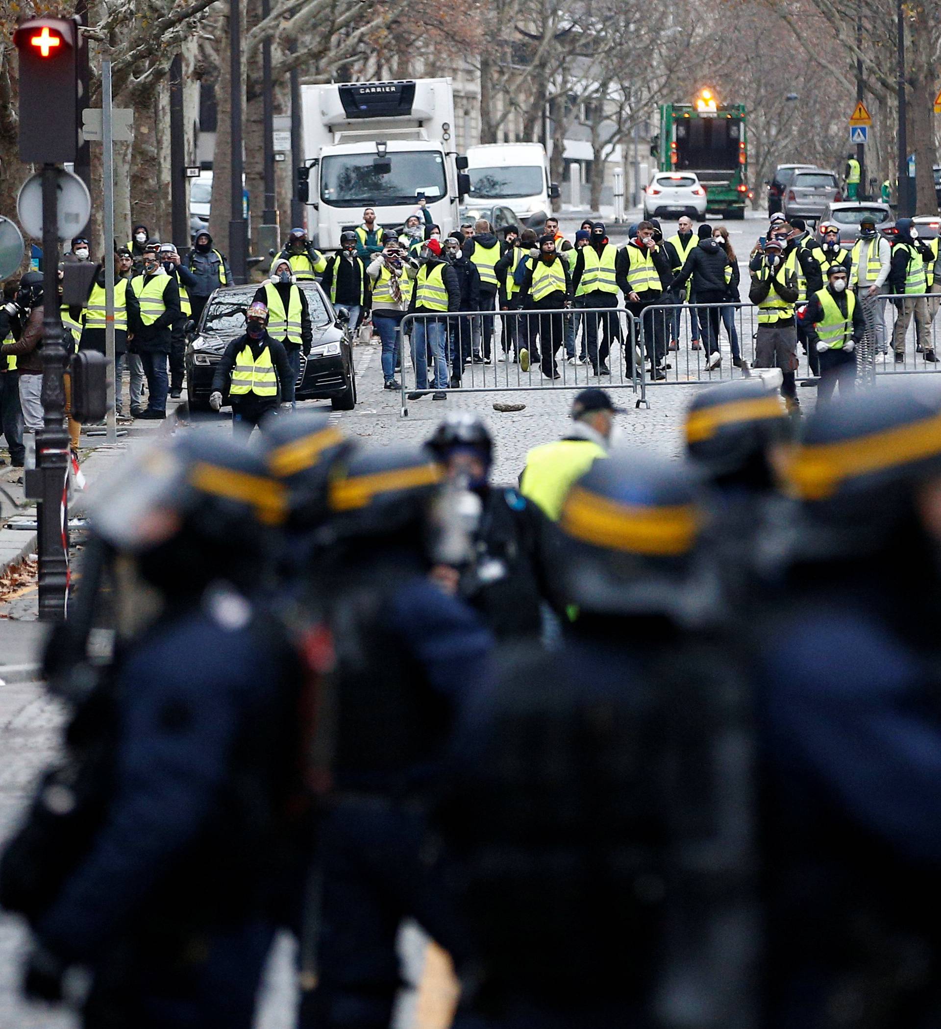 Police secure an area near protesters wearing yellow vests, a symbol of a French drivers' protest against higher diesel taxes, who gathter to demonstrate in Paris
