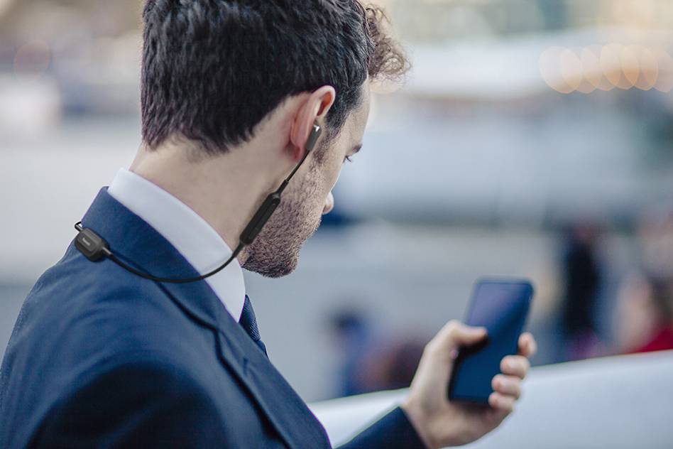 Over the shoulder view of businessman texting on smartphone