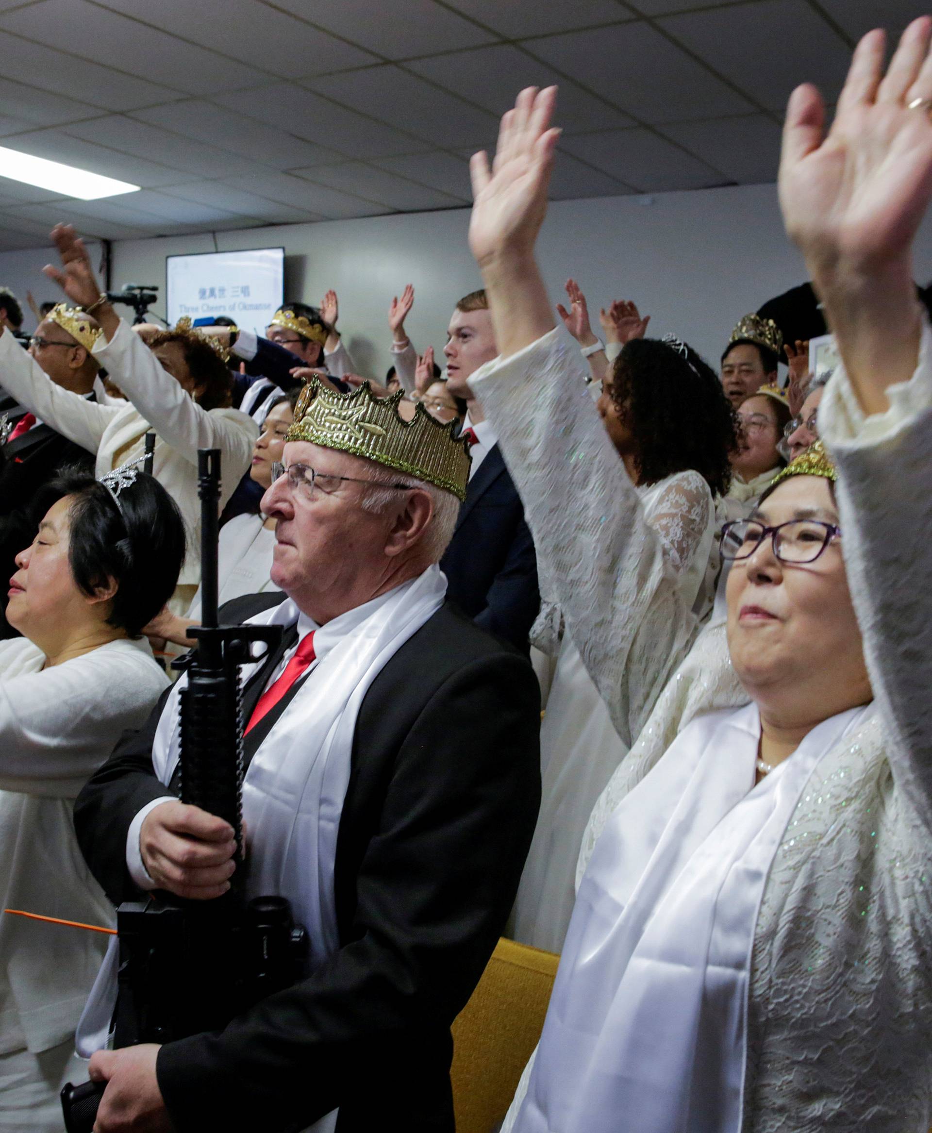 People with their AR-15-style rifles attend a blessing ceremony at the Sanctuary Church in Newfoundland