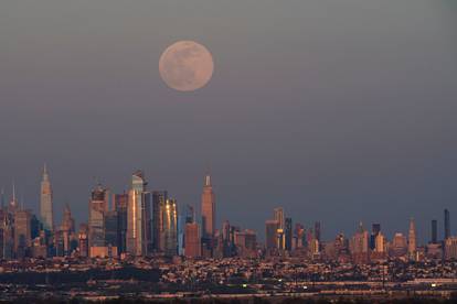 The full moon, known as the "Super Pink Moon", rises over the skyline of New York and Empire State Building, as seen from West Orange, in New Jersey