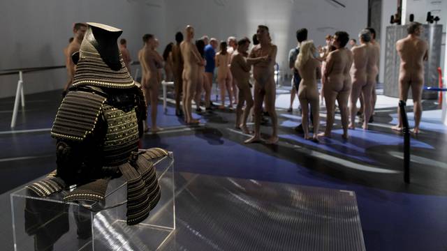 People take part in a nudist visit of the 'Discorde, Fille de la Nuit' season exhibition at the Palais de Tokyo contemporary art centre in Paris