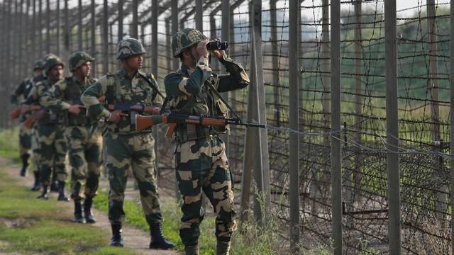 India's Border Security Force soldiers patrol along the fenced border with Pakistan in Ranbir Singh Pura sector