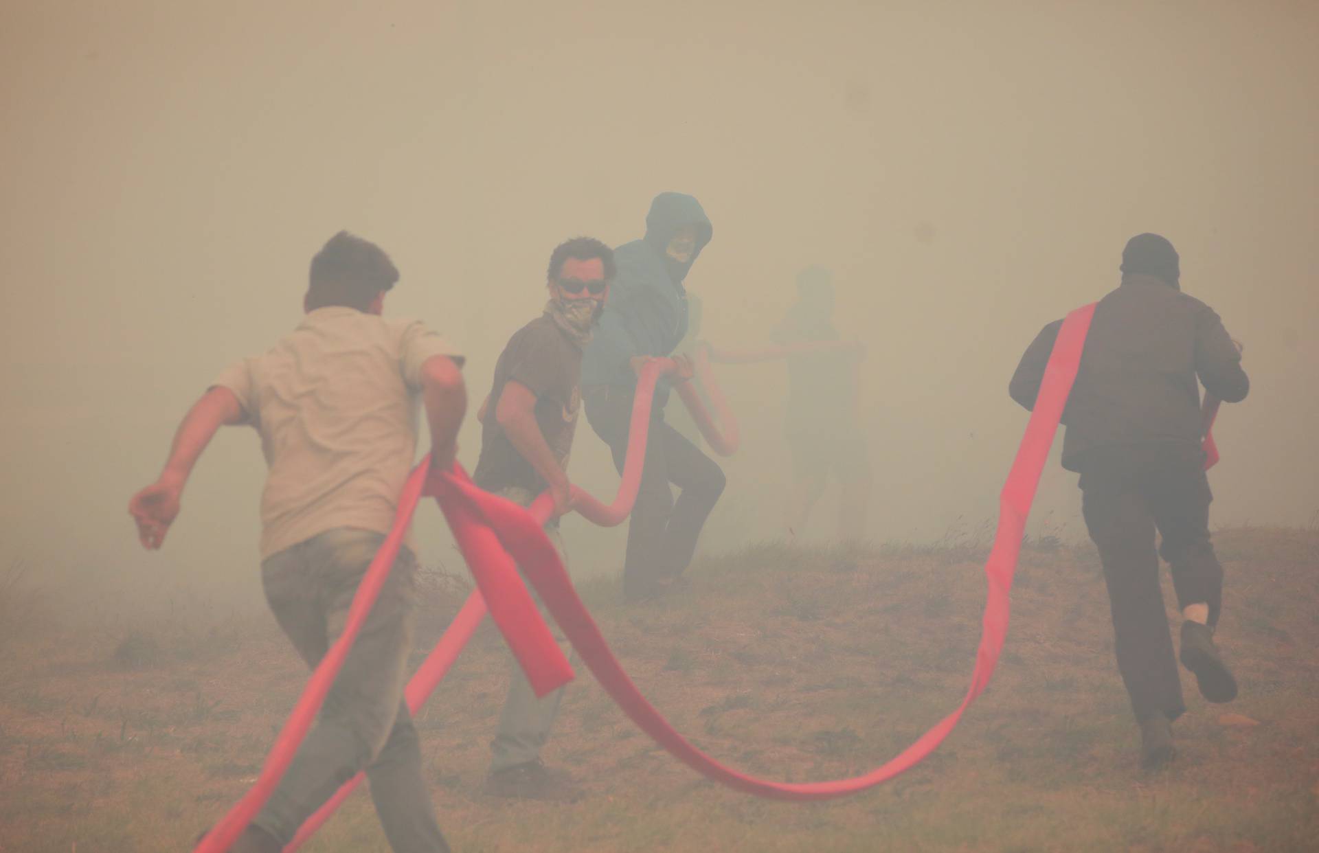 Firefighters battle to contain a fire fanned by strong winds on the slopes of Table Mountain in Cape Town