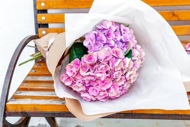 bouquet of peonies on a wooden bench