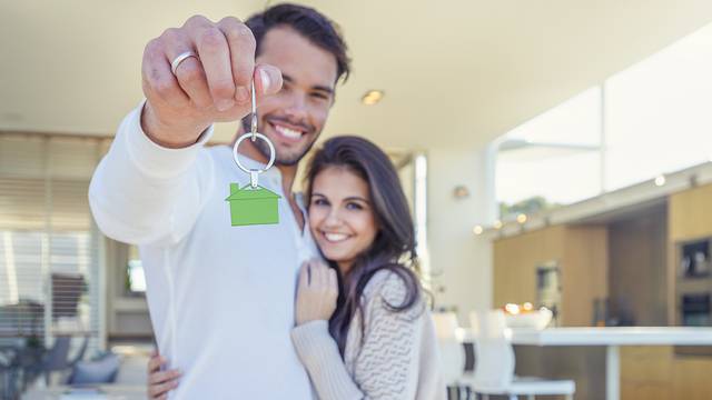 Couple holding a house key in their new home.