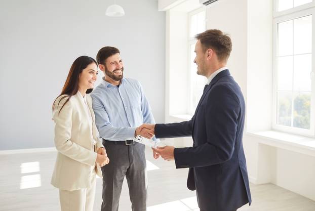 Family,Couple,Shakes,Hands,With,A,Real,Estate,Agent,Or