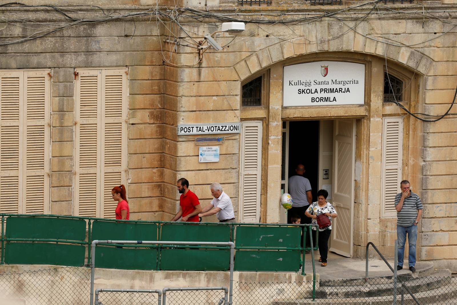 People leave a polling station after voting in European Parliament elections, in Cospicua